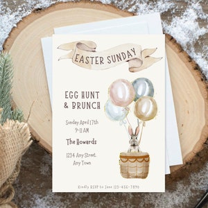 May include: An invitation to an Easter Sunday egg hunt and brunch. The invitation features a watercolor illustration of a bunny in a hot air balloon with pastel colored balloons. The text reads "Easter Sunday", "Egg Hunt & Brunch", "Sunday April 17th 9-11 AM", "The Howards", "1234 Any Street. Any Town", and "Kindly RSVP to Jane 123-456-7890".