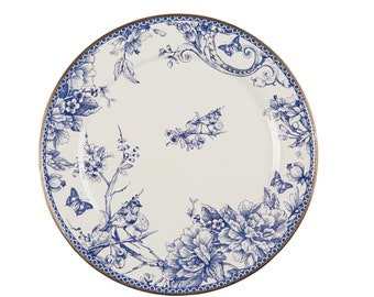May include: A white ceramic plate with a blue floral and bird design. The plate features a gold rim and a detailed pattern of flowers, butterflies, and birds. The design is reminiscent of classic porcelain.