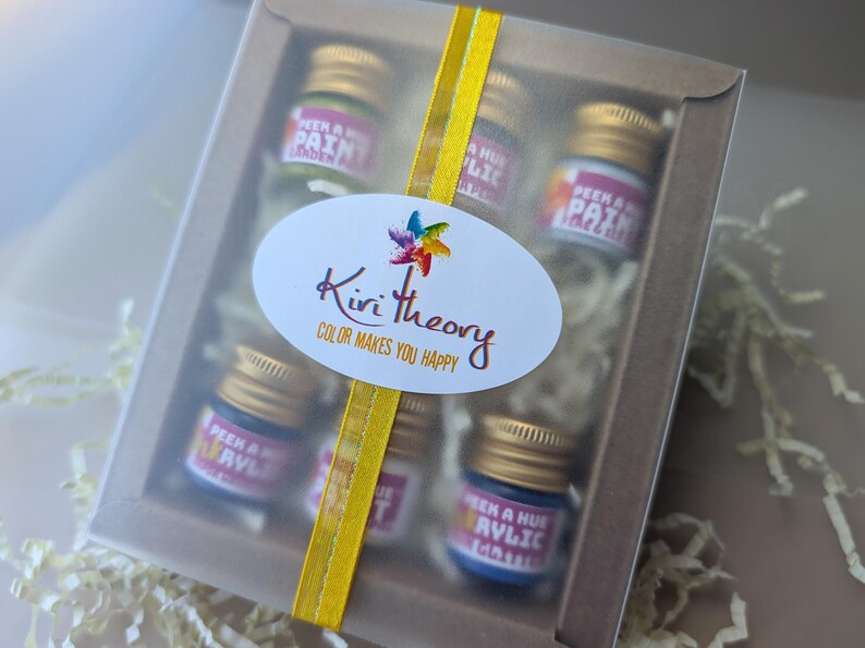 a colorful festive slide out box of petite acrylic ink and paint samples jars, with a bright yellow ribbon and cute colorful label.