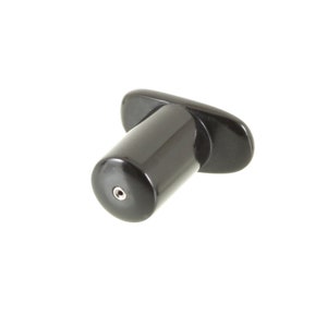 May include: A black bottle stopper with a cylindrical body and a flat, curved handle. The stopper has a small, circular opening at the bottom. The object is set against a white background.