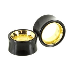 May include: Pair of black and gold ear gauges. The gauges are made of wood and have a gold metal inlay.