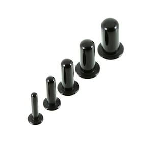 以下が含まれることがあります： さまざまなサイズで6つの黒いプラスチック製のイヤーゲージのセット。ゲージは、フレアベースのあるシリンダーの形をしています。