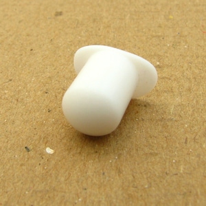 May include: White plastic cap with a flat top and a rounded bottom.