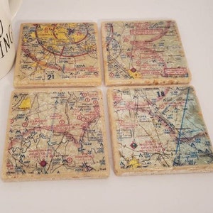 May include: Set of four square coasters featuring vintage maps with red, yellow, and blue markings. The maps are labeled with numbers 21 and 18.