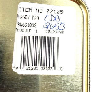 May include: A close-up of a metallic container with a white label. The label includes the text "ITEM NO 02105 HANDY MAN" and a barcode. Handwritten blue numbers and the date "10/23/98" are also visible.