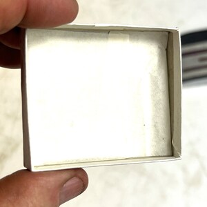 Op de afbeelding: Een witte kartonnen doos met een witte tissuepapier voering. De doos is leeg.