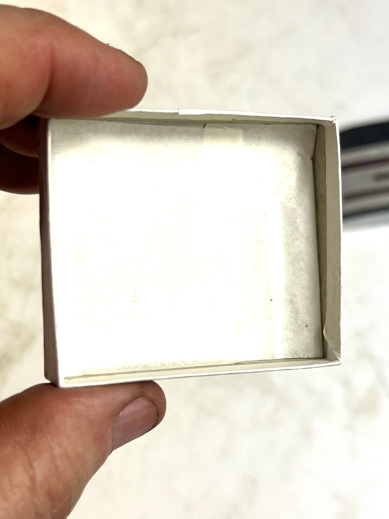 Op de afbeelding: Een witte kartonnen doos met een witte tissuepapier voering. De doos is leeg.