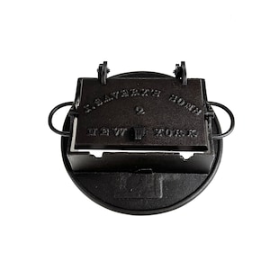Puede incluir: Wafflera de hierro fundido negro con el texto "J. SAVERY'S HONG" y "EST. 1877 YORK" en la parte superior.