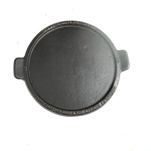 May include: Black cast iron griddle with two handles and the text "GRAVYROULETTA'S KITCHEN" and "IRON FOUNDRY CASTING PLANT" around the edge.