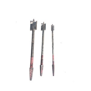 May include: Three drill bits with black and red painted shafts and pointed tips.