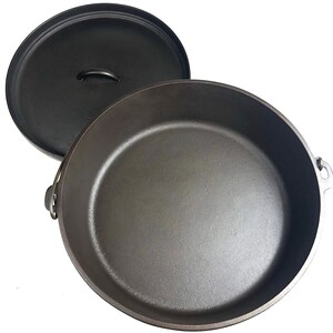 Puede incluir: Una olla de hierro fundido negra con tapa. La olla tiene dos asas a los lados y una en la tapa.