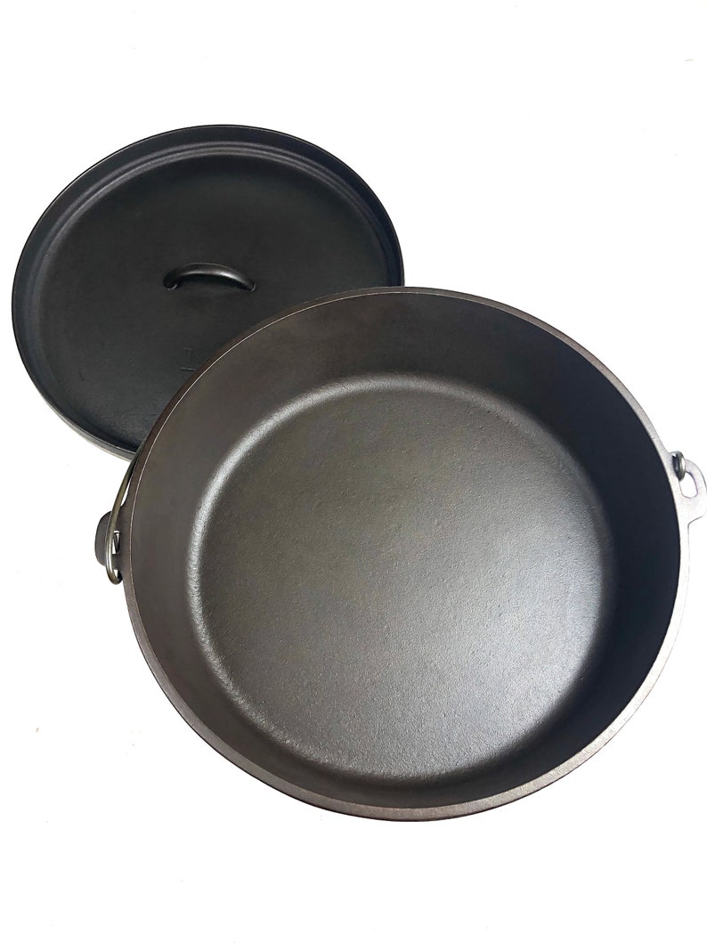 Puede incluir: Una olla de hierro fundido negra con tapa. La olla tiene dos asas a los lados y una en la tapa.