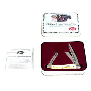 May include: A limited edition Case pocketknife set. The set includes a knife with a cream-colored handle, two blades, and the text "CASE RA 2653". The set comes in a metal tin with the text "W.R. Case & Sons Cutlery Co."