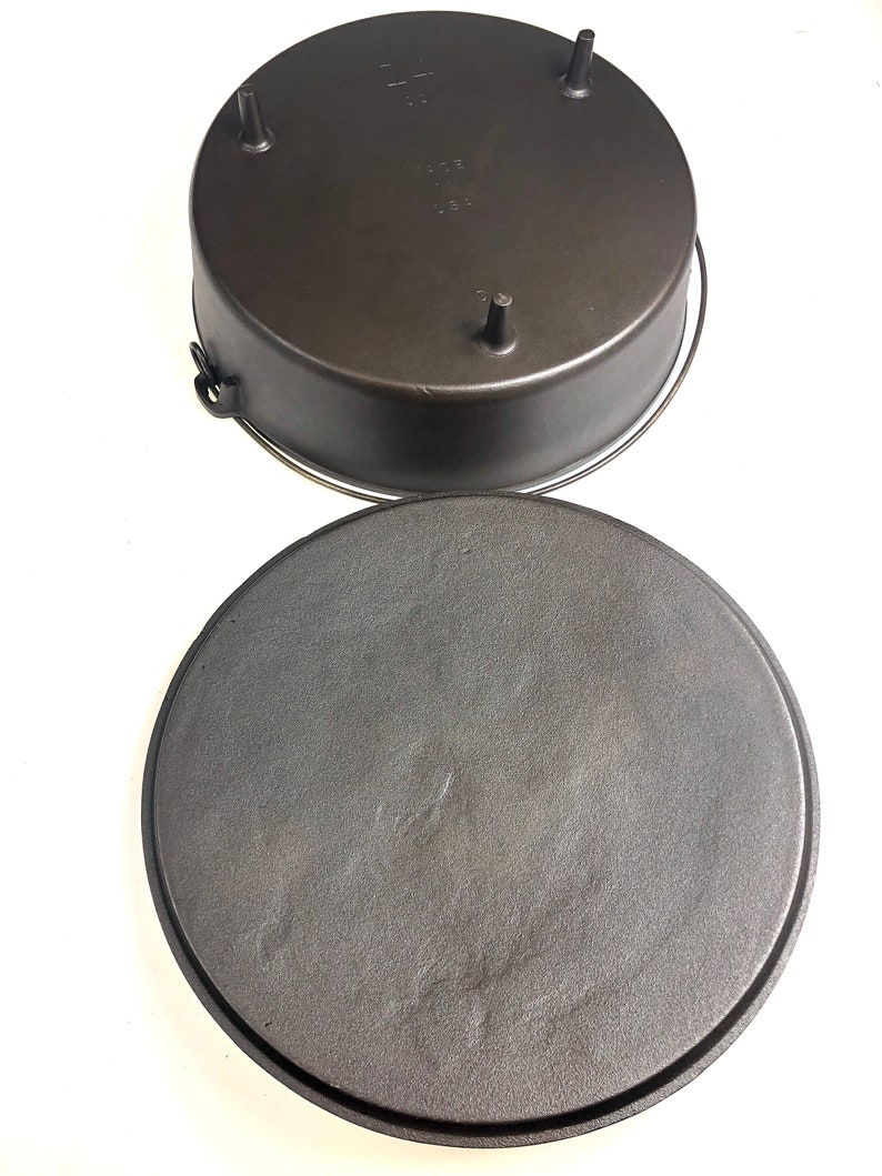 Puede incluir: Una olla de hierro fundido negra con tapa. El fondo de la olla tiene tres patas peque&ntilde;as y la tapa tiene un asa.