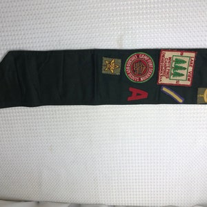 May include: A green Boy Scout neckerchief with various patches, including a "Camp Fort Dearborn" patch, a "White Pines Camporee" patch, and a "Lake View" patch.