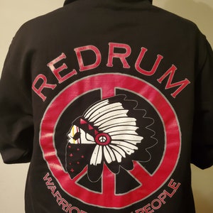 May include: Black hooded sweatshirt with a red circle and peace sign graphic. The graphic features a Native American headdress and the text "REDRUM WARRIORS 4 THE PEOPLE".