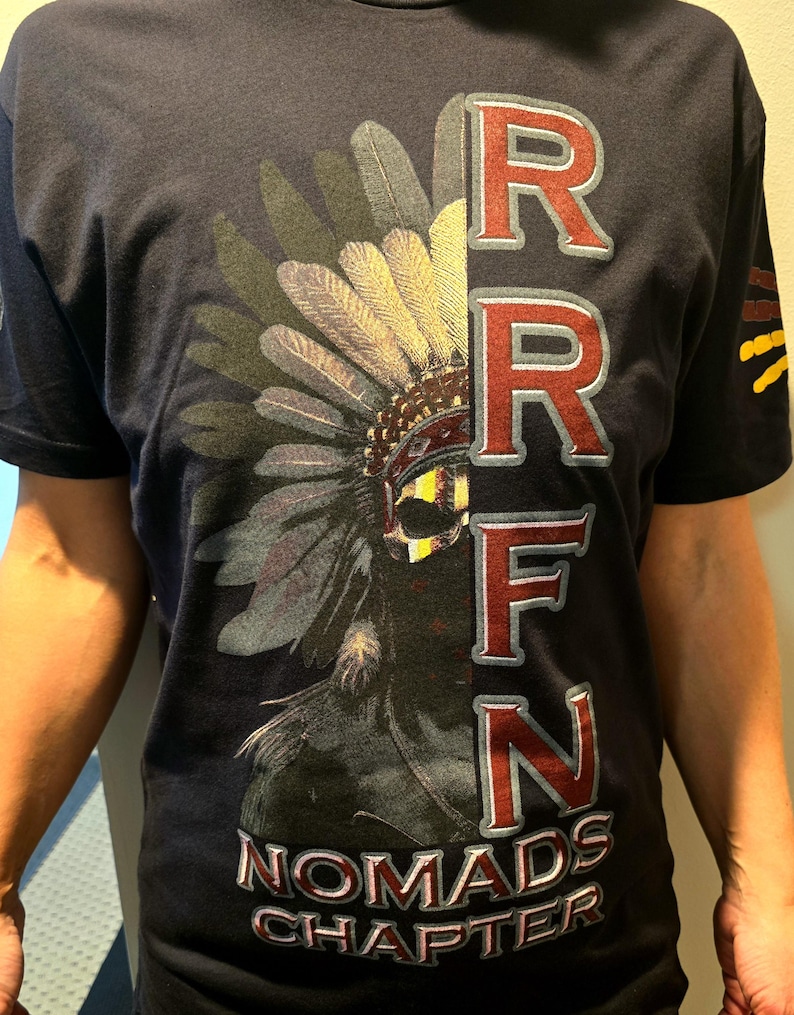 May include: A navy blue t-shirt with a graphic of a Native American headdress and the text "RRFN NOMADS CHAPTER" printed in red and white.