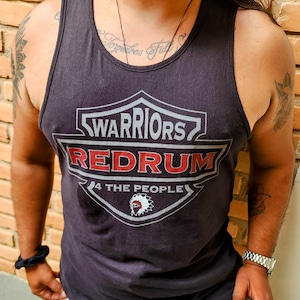 Op de afbeelding: Zwart tanktop met een grijs en rood grafisch ontwerp. De grafiek toont een schild met de tekst "WARRIORS REDRUM 4 THE PEOPLE".