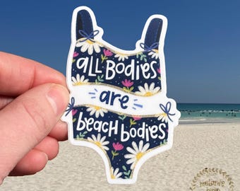 May include: A blue and white swimsuit sticker with the text "ALL BODIES are BEACH BODIES" in a white banner. The swimsuit is decorated with white daisies and pink flowers.