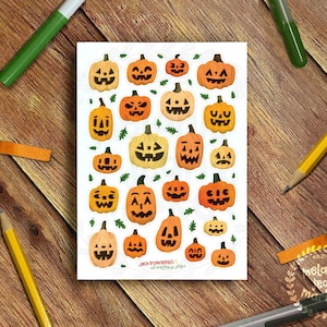 May include: A sheet of 20 Halloween stickers featuring orange and yellow jack-o'-lantern faces with different expressions. The stickers are on a white background with green leaves.