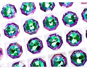 May include: A close-up of a tray of iridescent green and purple octagon-shaped rhinestones. The rhinestones have a hole in the center for sewing or attaching to a project.