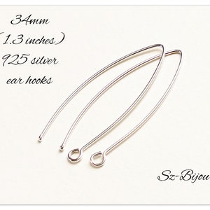 Pu&ograve; includere: Due ganci per orecchini in argento, lunghi 34 mm (1,3 pollici), realizzati in argento 925. I ganci per orecchini sono su uno sfondo bianco.