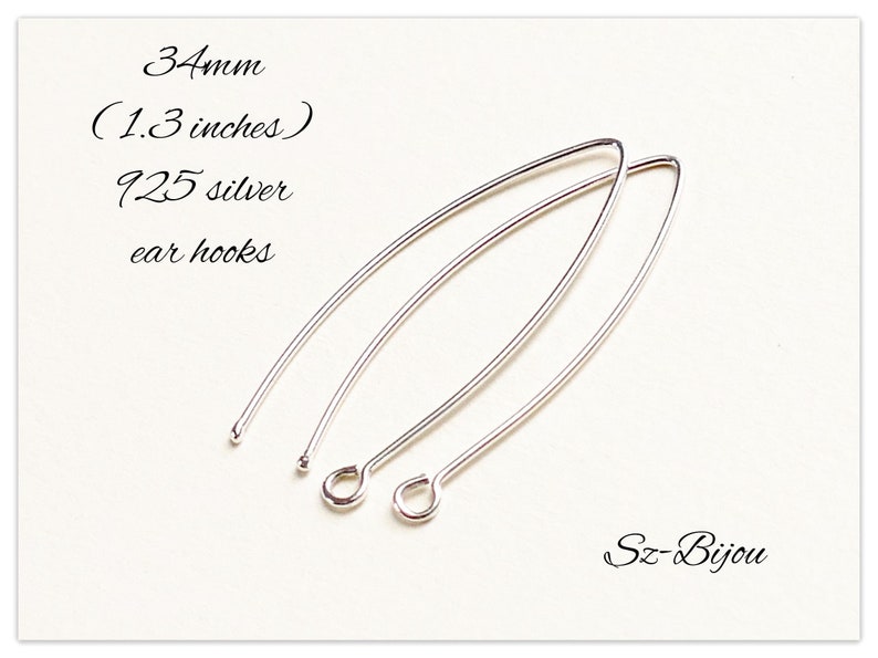 Pu&ograve; includere: Due ganci per orecchini in argento, lunghi 34 mm (1,3 pollici), realizzati in argento 925. I ganci per orecchini sono su uno sfondo bianco.