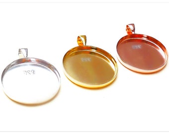 May include: Three oval-shaped metal pendant trays with a bail loop at the top. The trays are silver, gold, and copper.