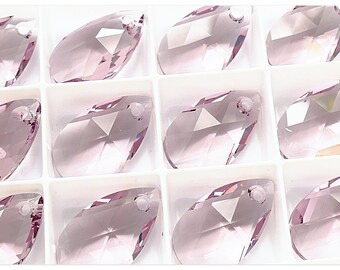 Peut inclure: Gros plan sur douze pendentifs en cristal transparents, facetés, en forme de larme, de couleur rose clair. Les pendentifs sont disposés en grille dans un récipient en plastique blanc.