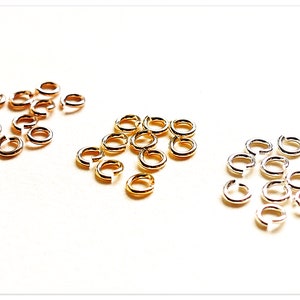 May include: Three groups of jump rings in gold, silver, and white metal. Each group contains approximately 15 jump rings.