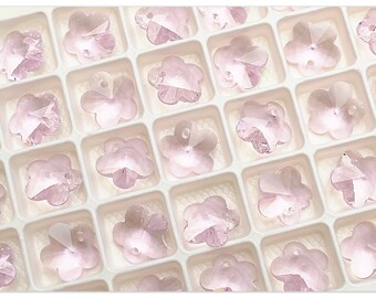 Könnte beinhalten: Eine Platte mit rosa blütenförmigen Kristallperlen in einem durchsichtigen Plastikbehälter. Die Perlen sind in Reihen und Spalten angeordnet.
