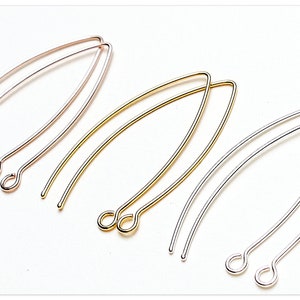 Può includere: Tre paia di fermagli per orecchini in oro, oro rosa e argento. Ogni paio è realizzato in filo sottile e curvo con un piccolo anello a un'estremità.