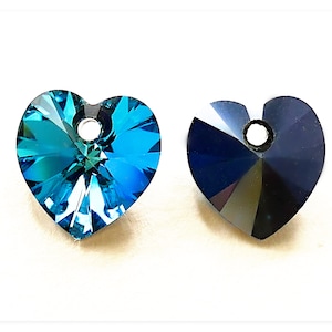 May include: Two heart-shaped crystal pendants, one in a vibrant teal blue and the other in a deep, rich black. Both pendants have a small hole at the top for stringing.