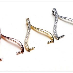 Puede incluir: Tres cierres de colgante de plata, oro y oro rosa con un diseño ondulado y detalles de cristal transparente.