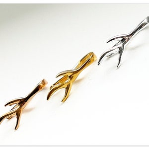 Puede incluir: Tres abalorios de metal en forma de cuerno de ciervo en oro, plata y oro rosa. Los abalorios están diseñados para ser utilizados como hallazgos de joyería.