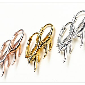 May include: Three pairs of hoop earrings with a deer antler design. The earrings are available in silver, gold, and rose gold.