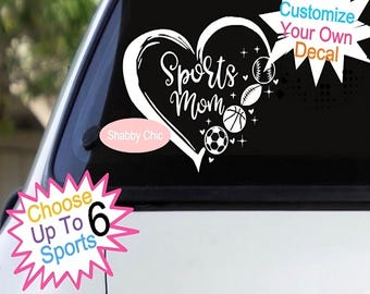 May include: A white decal featuring a heart shape with the words "Sports Mom" in cursive. Sports balls, including a baseball, football, basketball, and soccer ball, are included. Additional text reads "Customize Your Own Decal" and "Choose Up To 6 Sports."