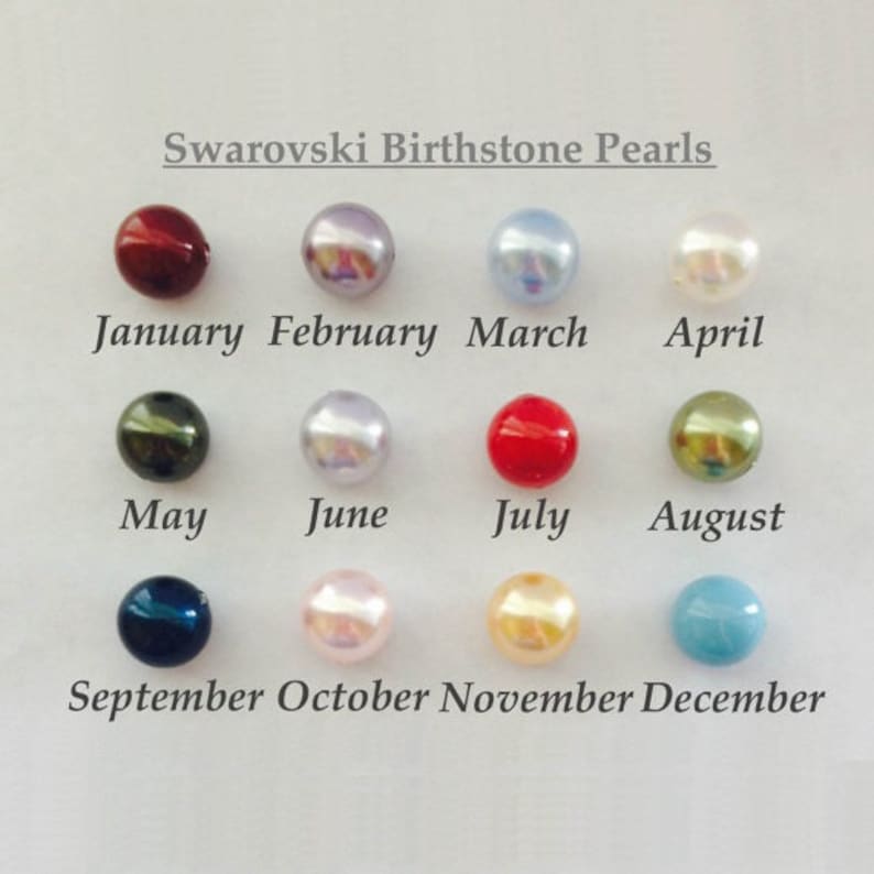 May include: Twelve Swarovski birthstone pearls in various colors, arranged in a grid. The pearls represent each month of the year, starting with January (red) and ending with December (light blue).