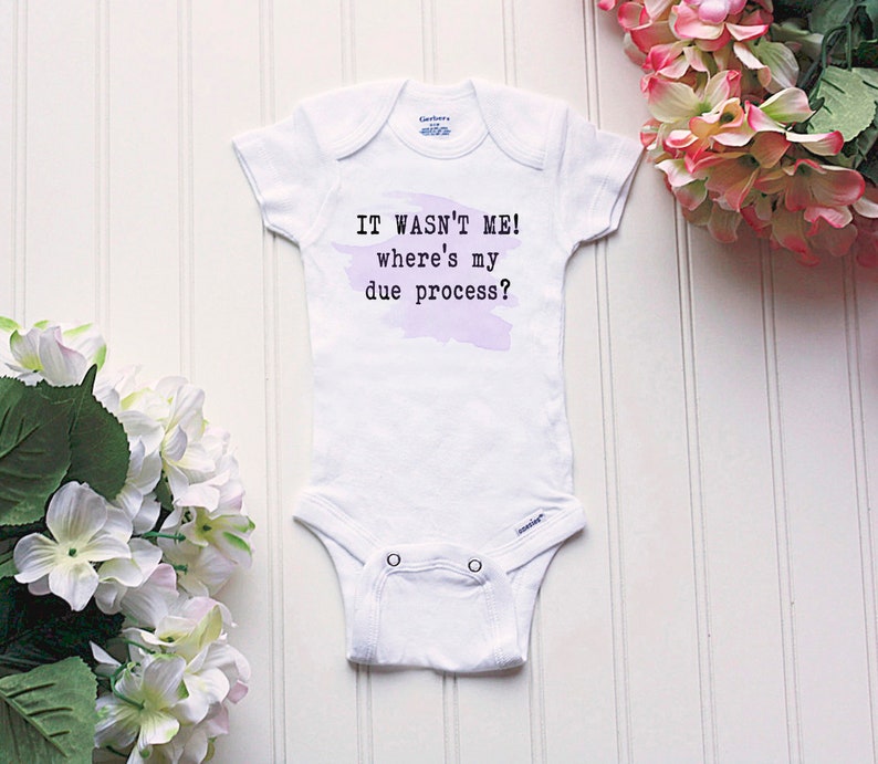 May include: White baby onesie with a purple watercolor background and the text "IT WASN'T ME! where's my due process?"