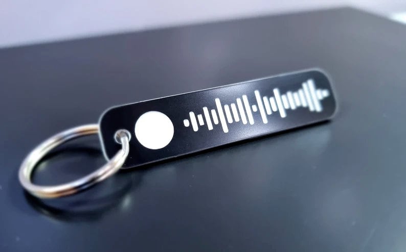 Pode incluir: Um chaveiro de metal preto com um c&oacute;digo Spotify branco e um anel prateado.