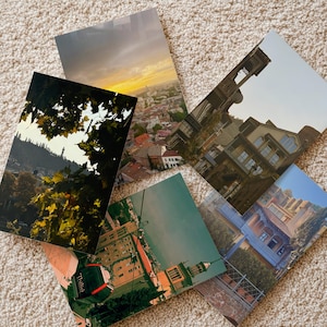 May include: A collection of six rectangular prints featuring scenic views. The prints showcase cityscapes, architecture, and landscapes, with a variety of colors and compositions. One print has the word "Tbilisi" on it.