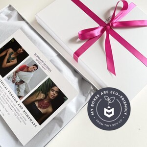 Eco-friendly white gift box with pink ribbon by ethical brand Jewelled Buddha with sticker that says "my boxes are eco-friendly".