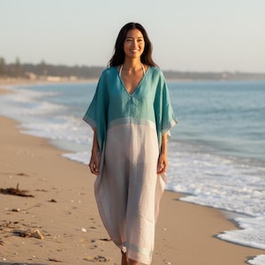 Woman walking on sandy beach wearing a linen beach kaftan dress