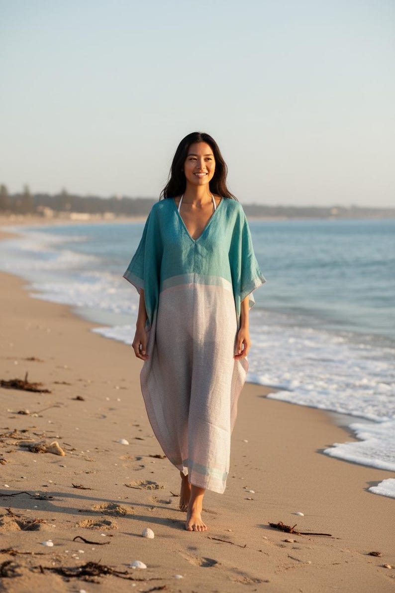 Woman walking on sandy beach wearing a linen beach kaftan dress