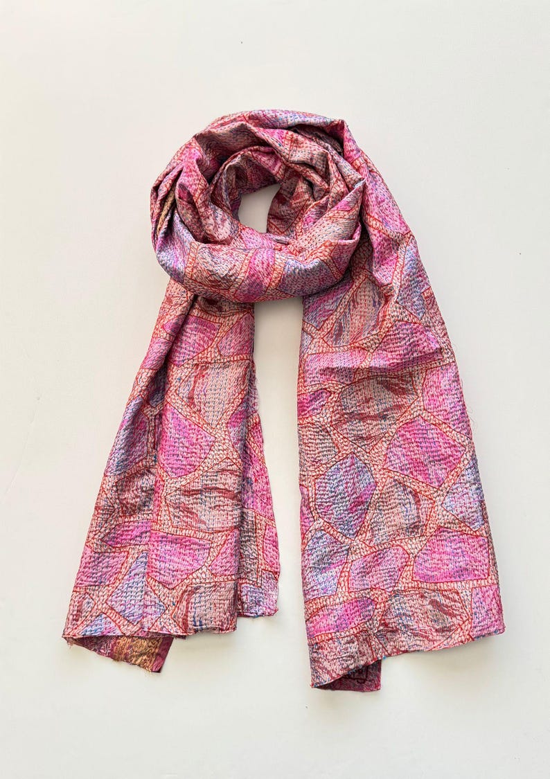 Pretty upcycled sari silk kantha scarf looped on a white background, the scarf has an abstract print and is handmade with tiny running stitches embroidered all over.