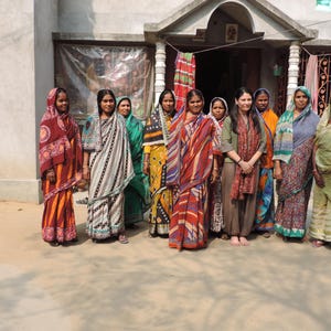 Group shot of Indian kantha artisan women with founder of Jewelled Buddha clothing brand Harjit Sohotey-Khan in village in Bengal