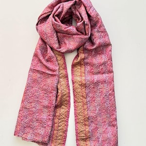 Upcycled sari silk pink and gold scarf looped on a plain white background, the scarf is handmade from vintage preloved sari silk and upcycled with tiny running stitches called Kantha stitch to create a lightly quilted texture. The scarf has a delicate floral print and embellished zari thread border running all the way down.