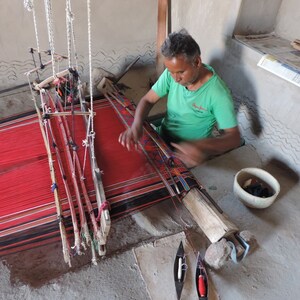Artisan in Rajasthan using a  pitloom to weave a rug in the traditional kashida stitch.