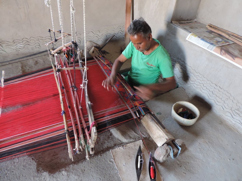 Artisan in Rajasthan using a  pitloom to weave a rug in the traditional kashida stitch.