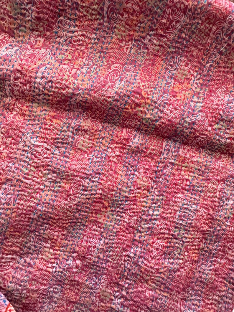 Close up detail of floral patterns on a upcycled sari silk scarf with hand embroidered Kantha running stitch to create a lightly quilted look.